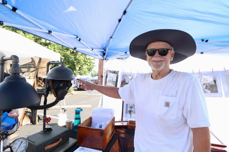 Greg Deming of Middletown shows off an old Army helmet, gas mask and ammo box from World War II that he repurposed into a lamp. Deming said he tries to marry the Industrial Revolution to the machine age to create the lamps.
